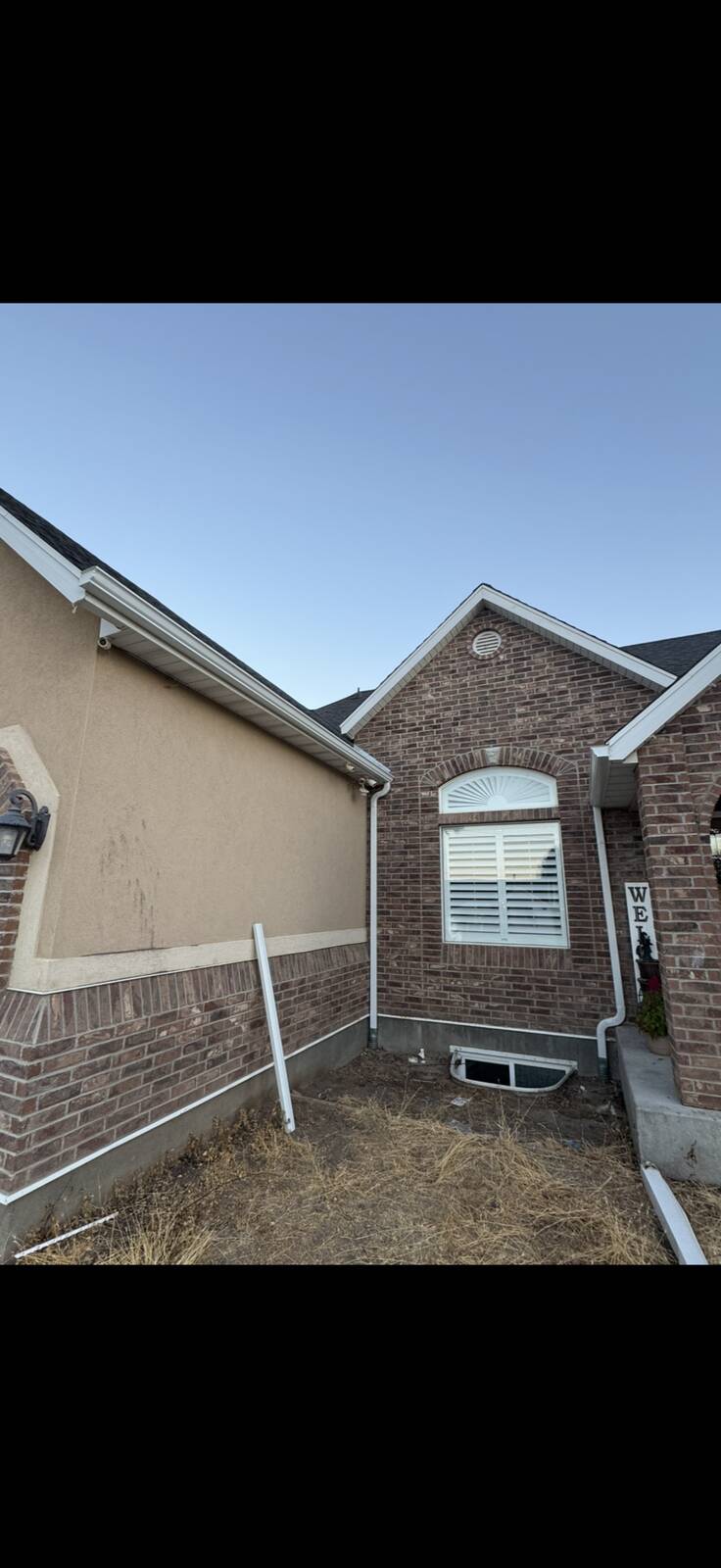 White seamless gutters installed on the front facade of a traditional brick home